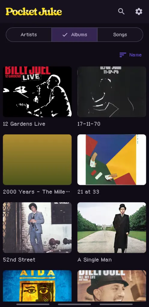 The Albums tab sorted by name, a grid of album covers with one generated gradient