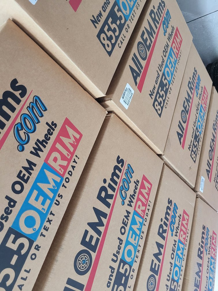 Stacks of the printed corrugated shipping boxes, each one carrying a barcode label