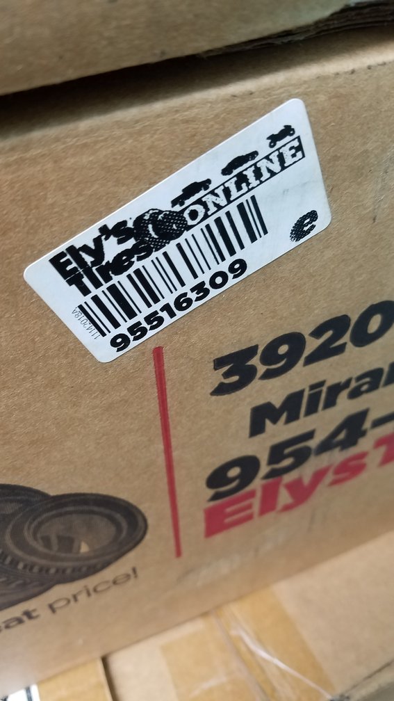A boxed wheel carrying an Ely's Tires Online barcode label